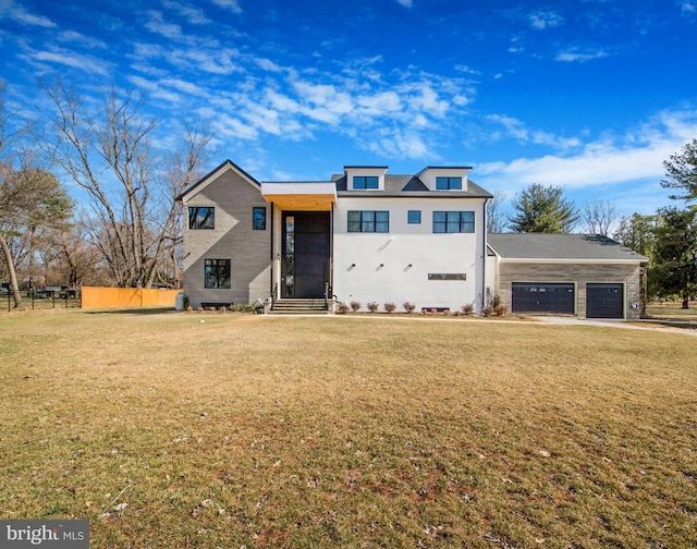 view of front of home featuring a front lawn, fence, and a garage