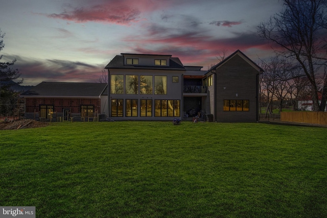 rear view of property with a lawn and fence