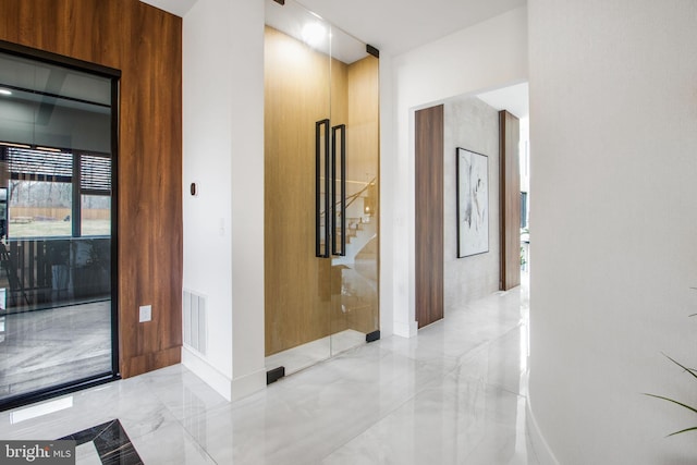 hallway featuring stairway, visible vents, and marble finish floor