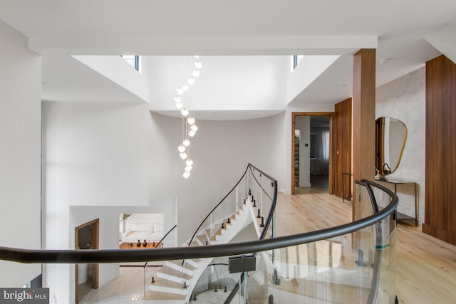 stairway with a high ceiling and wood finished floors