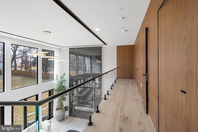 corridor featuring recessed lighting, stairway, and light wood-style floors