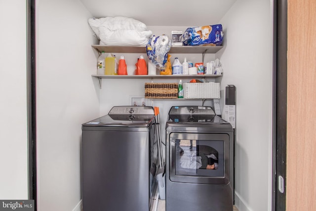 laundry room featuring laundry area, baseboards, and separate washer and dryer