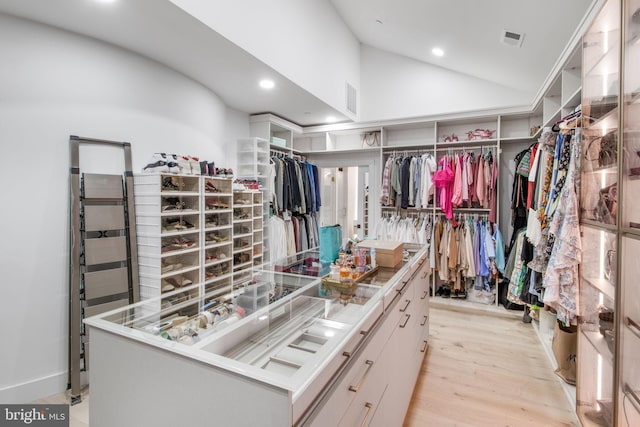 walk in closet featuring vaulted ceiling, visible vents, and light wood-type flooring