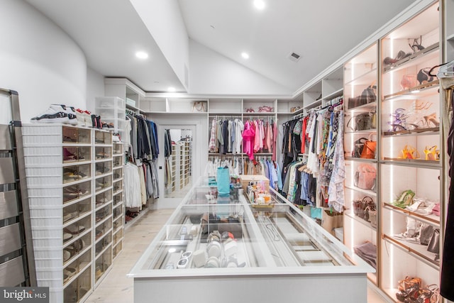 walk in closet with vaulted ceiling, wood finished floors, and visible vents