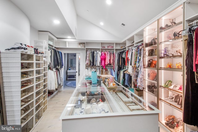 walk in closet featuring vaulted ceiling, wood finished floors, and visible vents