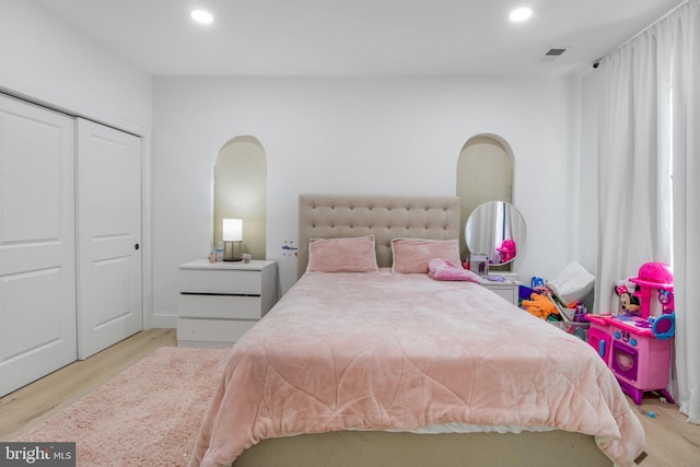 bedroom featuring recessed lighting, visible vents, arched walkways, and wood finished floors