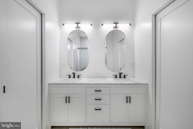 full bathroom with double vanity and a sink