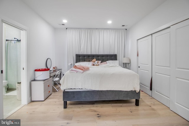 bedroom with visible vents, light wood-type flooring, recessed lighting, a closet, and ensuite bath