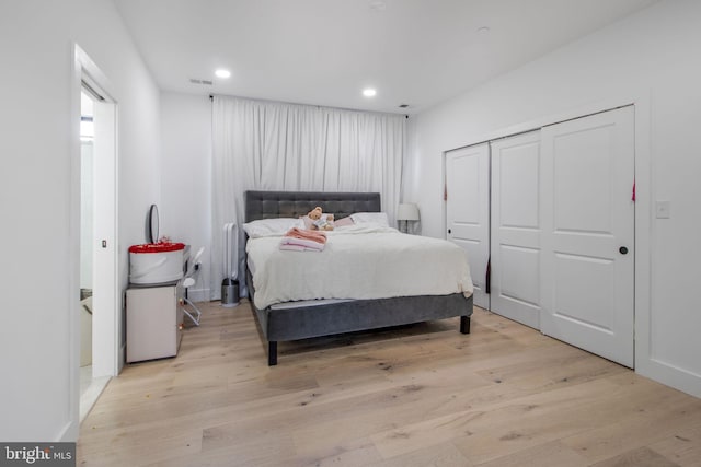 bedroom with recessed lighting, visible vents, a closet, and light wood finished floors