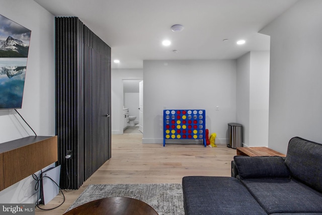 living room with recessed lighting, baseboards, and wood finished floors