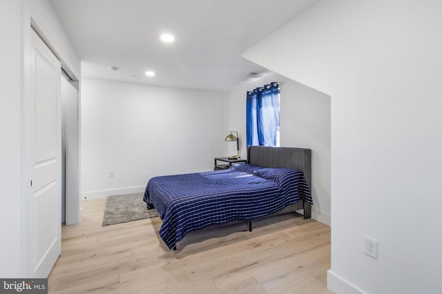 bedroom with recessed lighting, wood finished floors, and baseboards