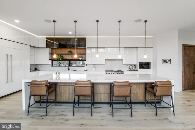 kitchen featuring light wood-style flooring, modern cabinets, white cabinets, and light countertops