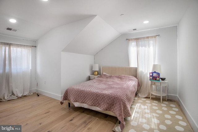 bedroom featuring vaulted ceiling, visible vents, and wood finished floors