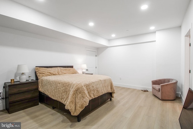 bedroom with recessed lighting, light wood-type flooring, and baseboards