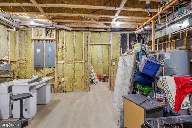 unfinished below grade area featuring gas water heater, electric panel, and wood finished floors