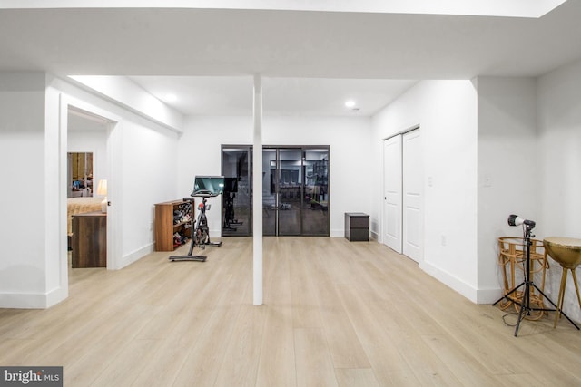 basement featuring baseboards and light wood-style flooring