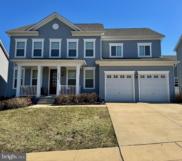 view of front of house with an attached garage, a porch, concrete driveway, and a front lawn