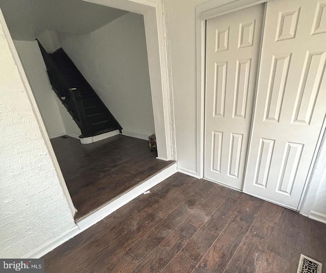 interior space featuring baseboards, visible vents, and wood-type flooring