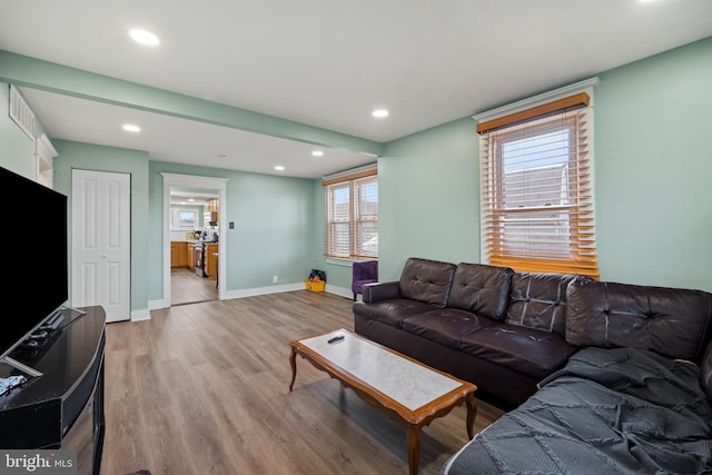 living area with recessed lighting, visible vents, baseboards, and light wood-style flooring