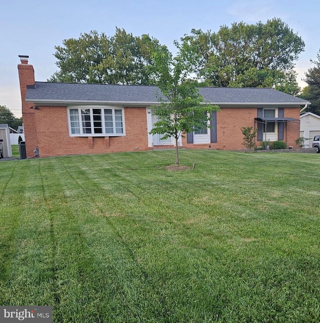 ranch-style house with a front lawn, brick siding, and a chimney