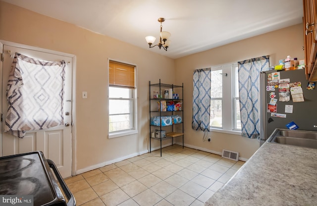 dining area featuring light tile patterned floors, visible vents, and a healthy amount of sunlight