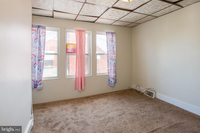 empty room featuring carpet flooring and a drop ceiling