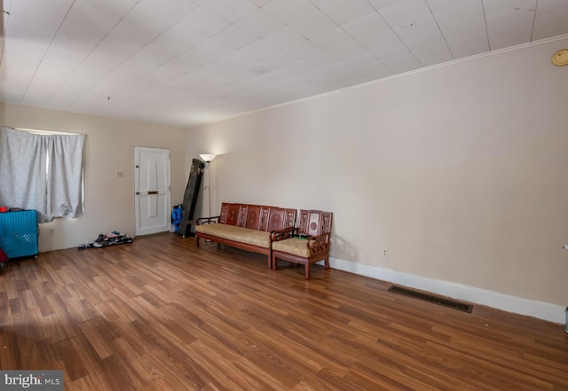 unfurnished room featuring visible vents, baseboards, and wood finished floors