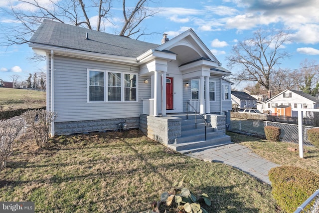 view of front of property featuring a front yard, fence, and a chimney