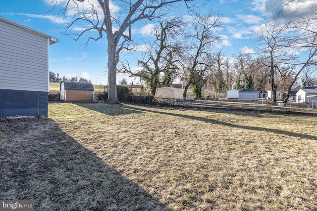 view of yard with an outdoor structure, fence, and a shed