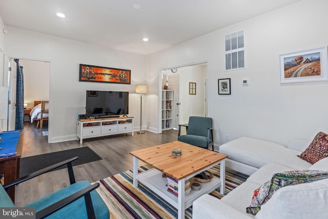 living area with recessed lighting, visible vents, baseboards, and wood finished floors