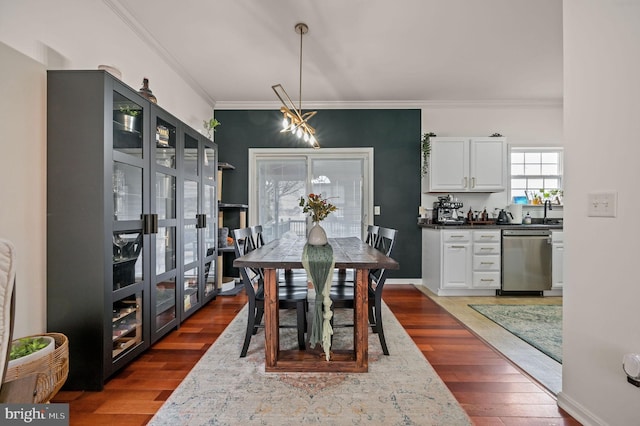 dining space featuring crown molding, dark wood-style floors, and baseboards