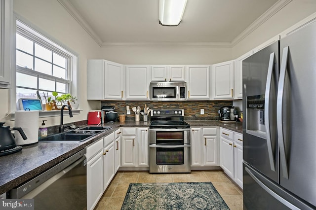 kitchen with white cabinetry, dark countertops, appliances with stainless steel finishes, and a sink