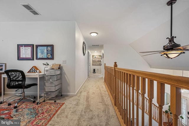 hall with visible vents, an upstairs landing, light colored carpet, and baseboards