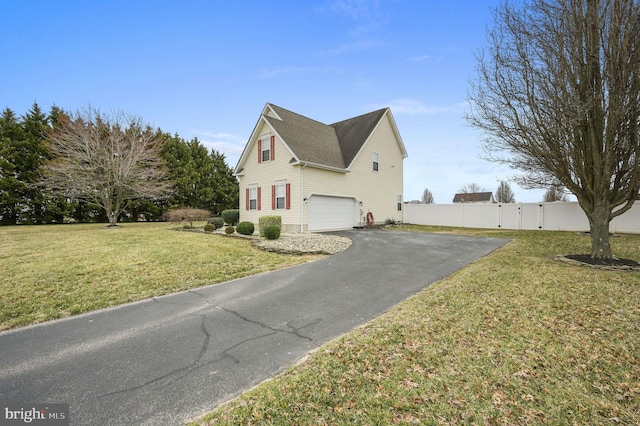 view of home's exterior featuring fence, a garage, driveway, and a lawn