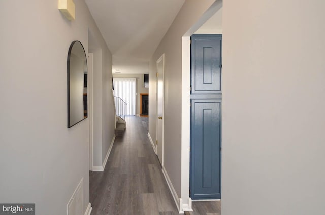 corridor featuring dark wood-style floors, visible vents, and baseboards