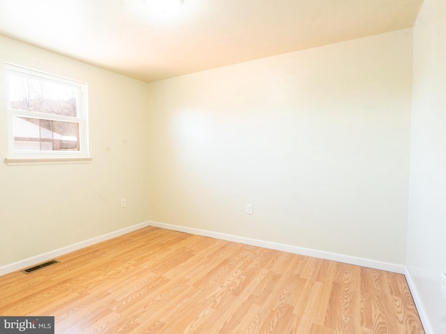 unfurnished room with visible vents, light wood-type flooring, and baseboards