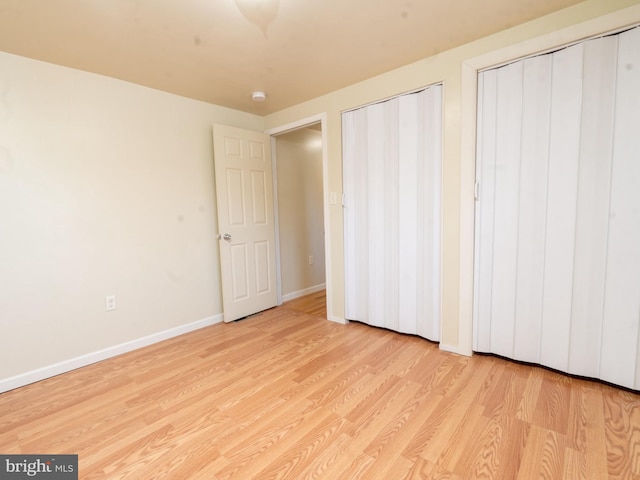 unfurnished bedroom with wood finished floors and baseboards