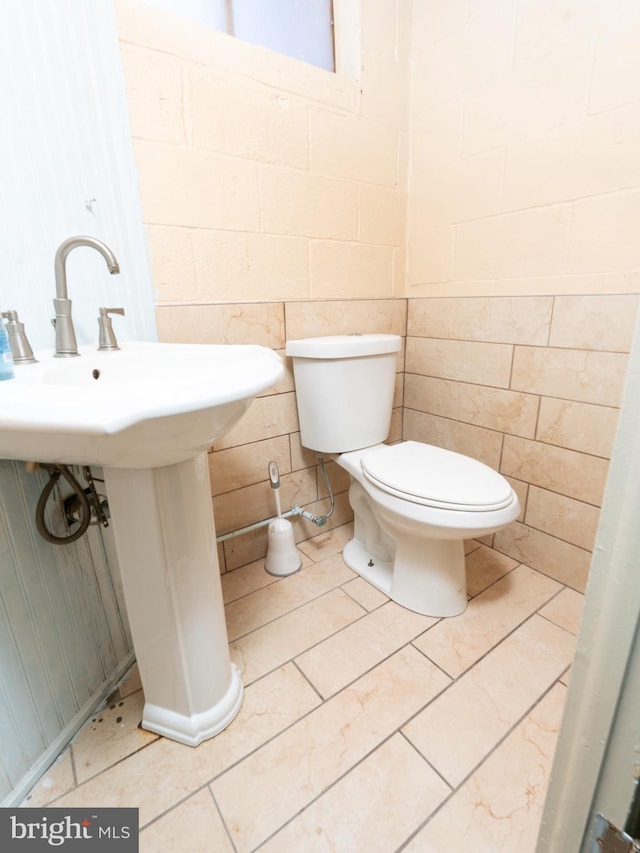 half bathroom with tile patterned flooring and toilet