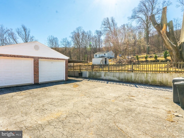 detached garage featuring fence