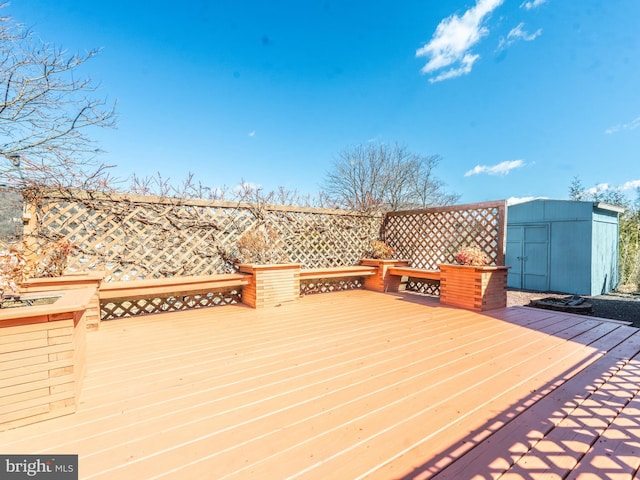 wooden terrace with a storage shed and an outdoor structure