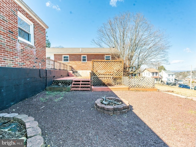 view of yard featuring a wooden deck and a fire pit