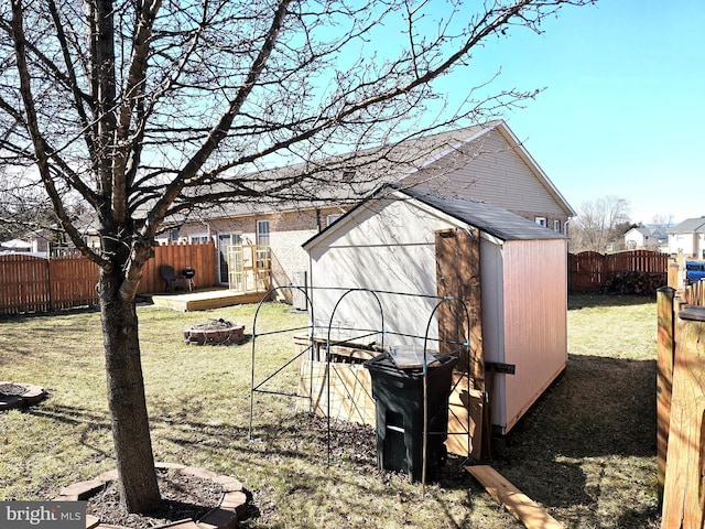 view of shed with a fire pit and a fenced backyard