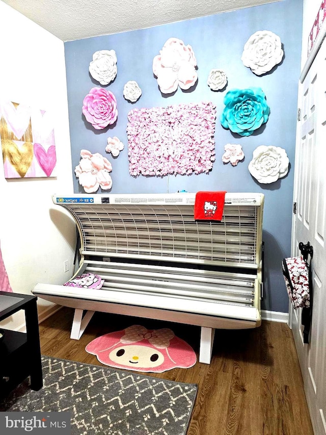 room details with a textured ceiling, baseboards, and wood finished floors