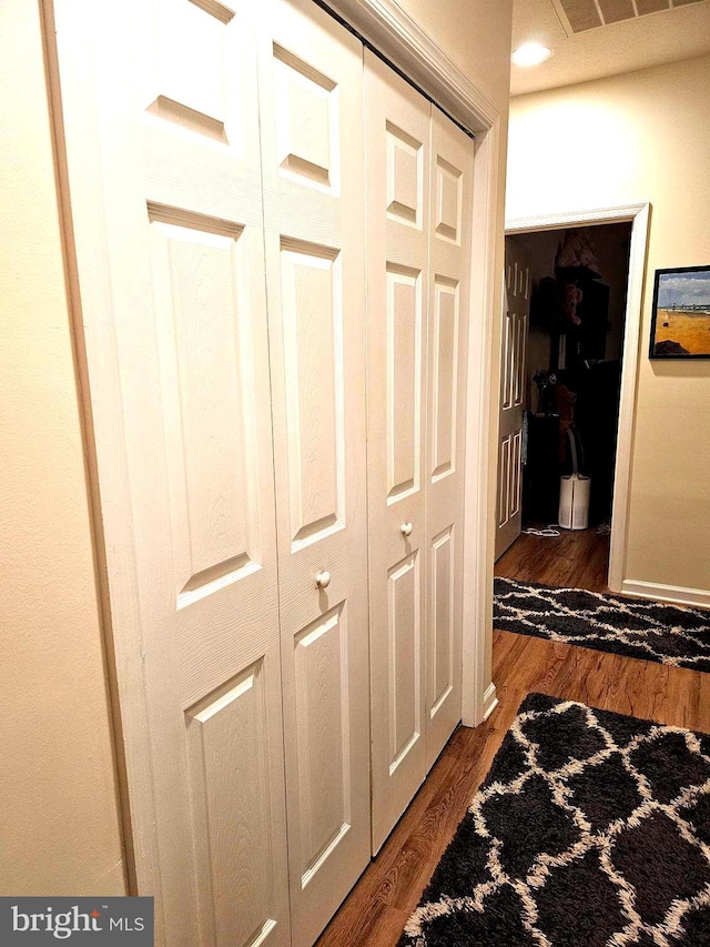 hall featuring visible vents and dark wood-type flooring