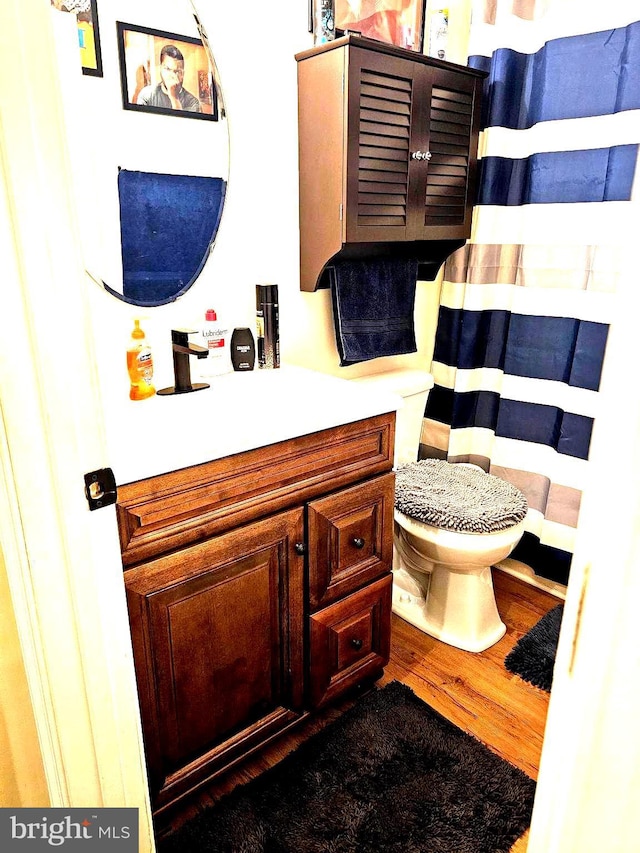 full bathroom with vanity, toilet, and wood finished floors