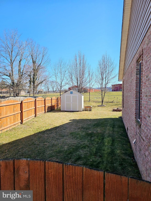 view of yard featuring an outdoor structure, a fenced backyard, and a shed