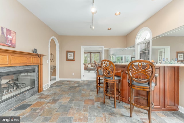 1052 Cedar Mill Ln, West Chester, PA 19382 - bar with a glass covered fireplace, arched walkways, healthy amount of natural light, and stone tile floors