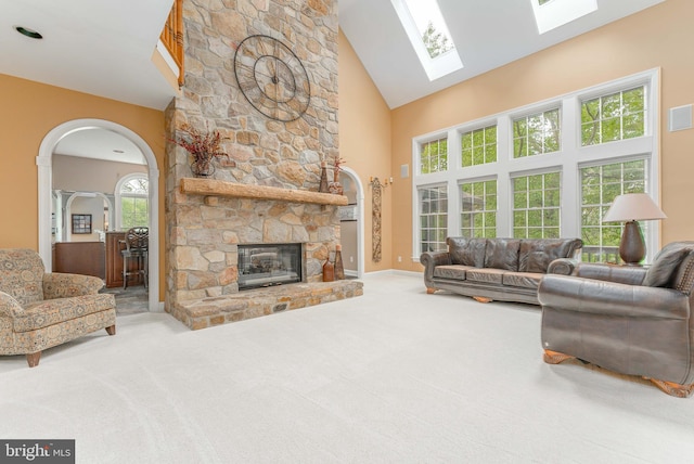 1052 Cedar Mill Ln, West Chester, PA 19382 - carpeted living area with high vaulted ceiling, arched walkways, a fireplace, and a skylight