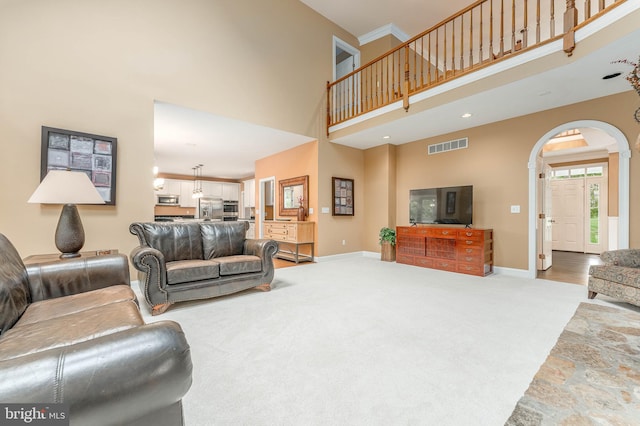 1052 Cedar Mill Ln, West Chester, PA 19382 - living area featuring arched walkways, a high ceiling, baseboards, and light carpet
