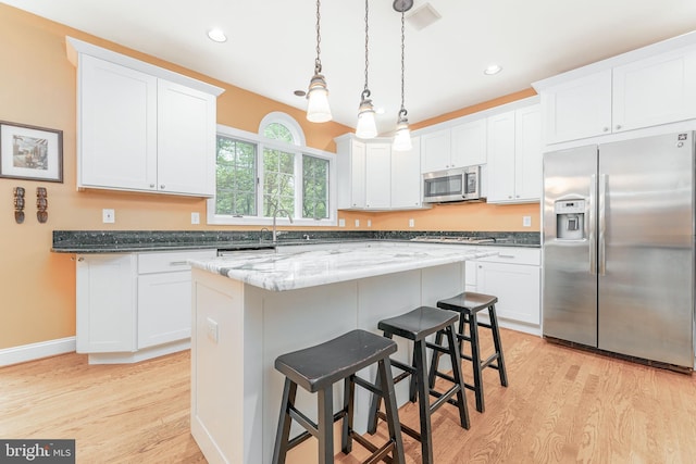 1052 Cedar Mill Ln, West Chester, PA 19382 - kitchen with stainless steel appliances, light wood-type flooring, a breakfast bar, white cabinets, and recessed lighting